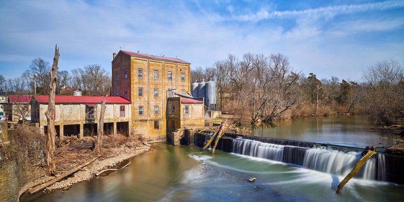 River in front of a historic brick building in Midway, Kentucky