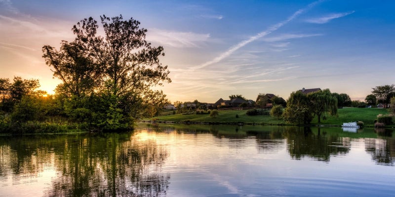 Beautiful pond at sunset with a Kentucky farm in the background